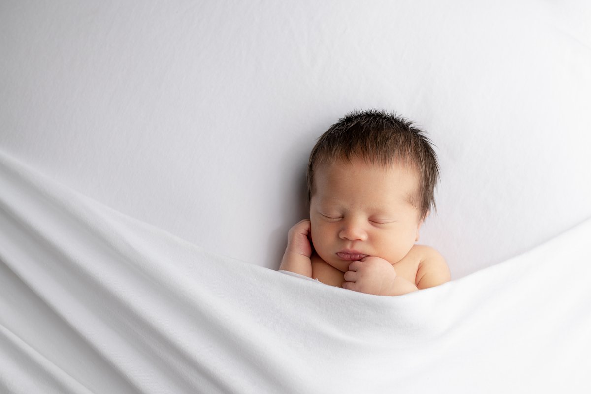 newborn baby on white blanket in mitchell sd studio newborn photographer