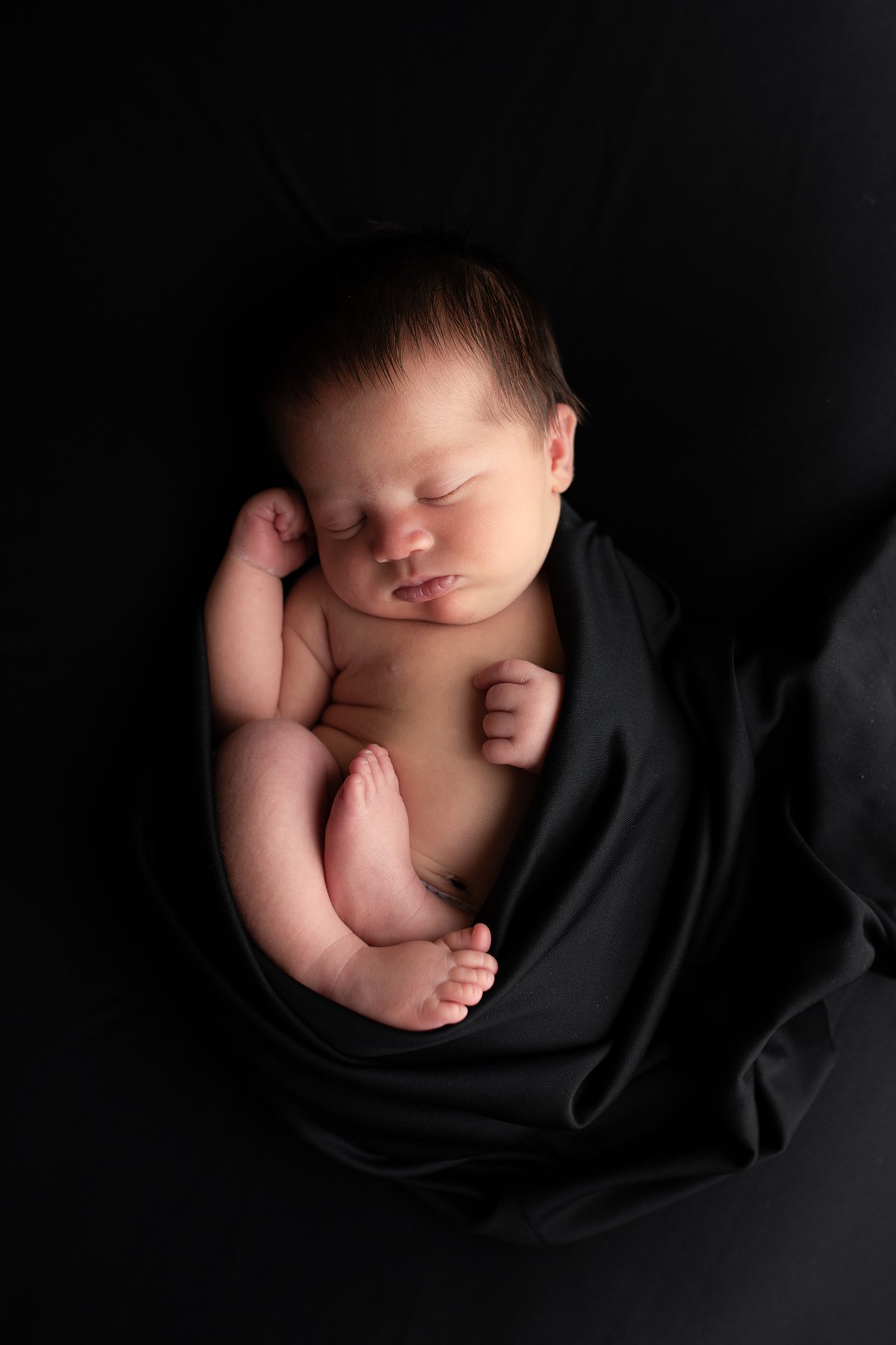 newborn baby wrapped in black newborn photographer mitchell sd