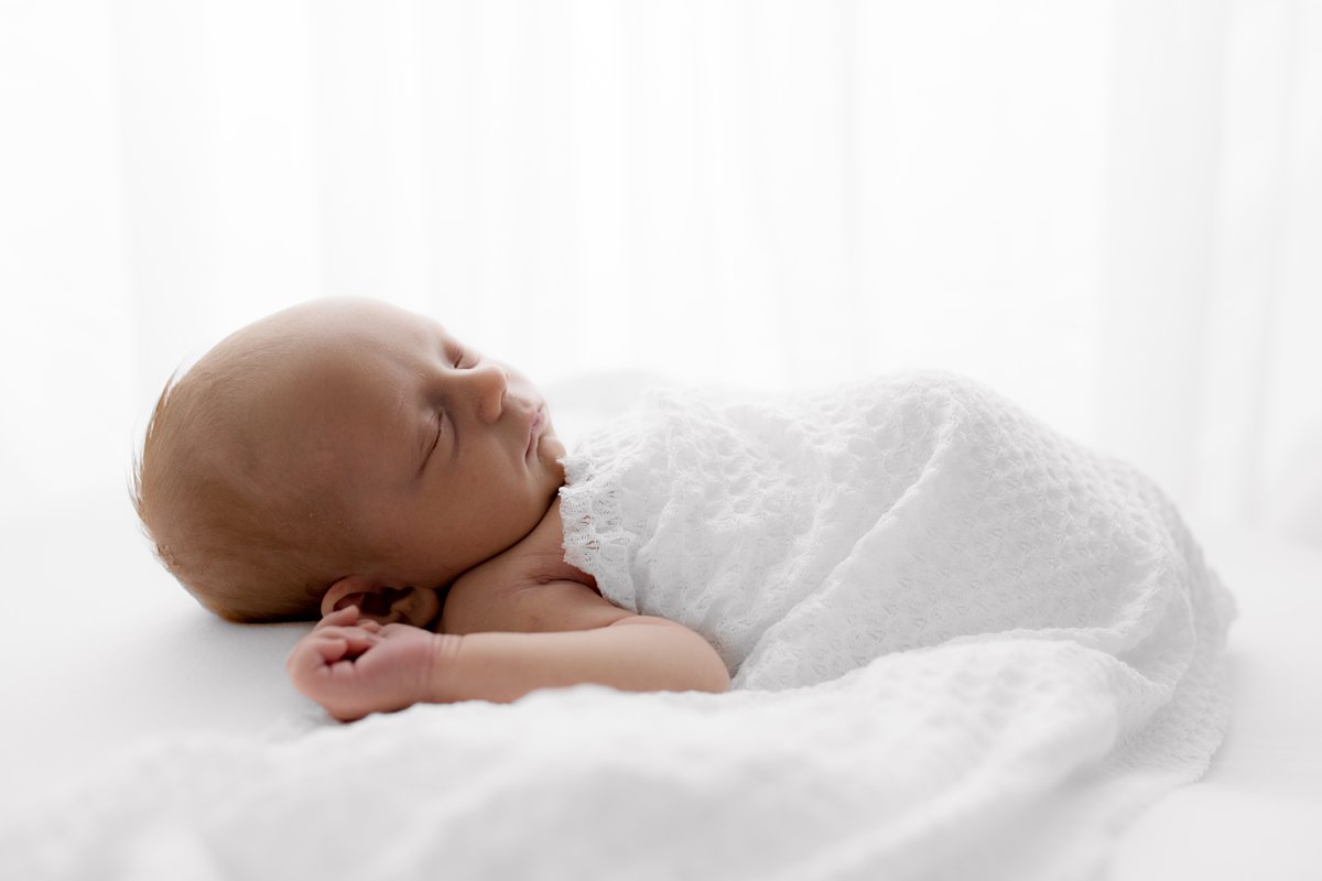 backlit newborn baby on white backdrop